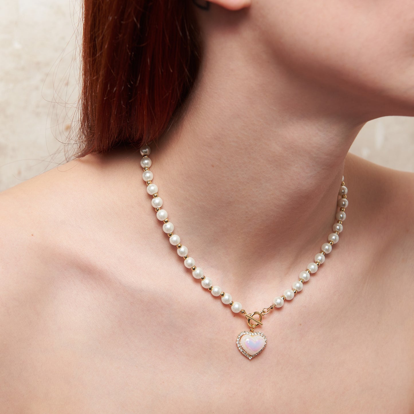 Sweet artificial pearls choker with iridescent heart pendant. Delicate front closure, one size, 38 cm. Zinc alloy & acrylic. Perfect for "soft girl" aesthetic with coquette charm & subtle elegance.
