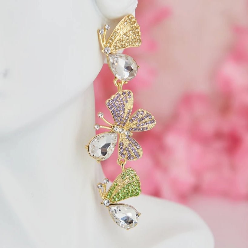 Statement maxi drop earrings with three golden butterflies adorned with sparkling details. Bold and elegant design.