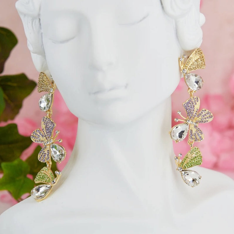 Statement maxi drop earrings with three golden butterflies adorned with sparkling details. Bold and elegant design.