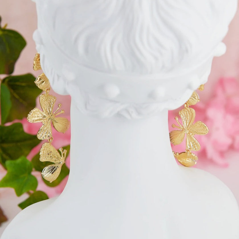 Statement maxi drop earrings with three golden butterflies adorned with sparkling details. Bold and elegant design.