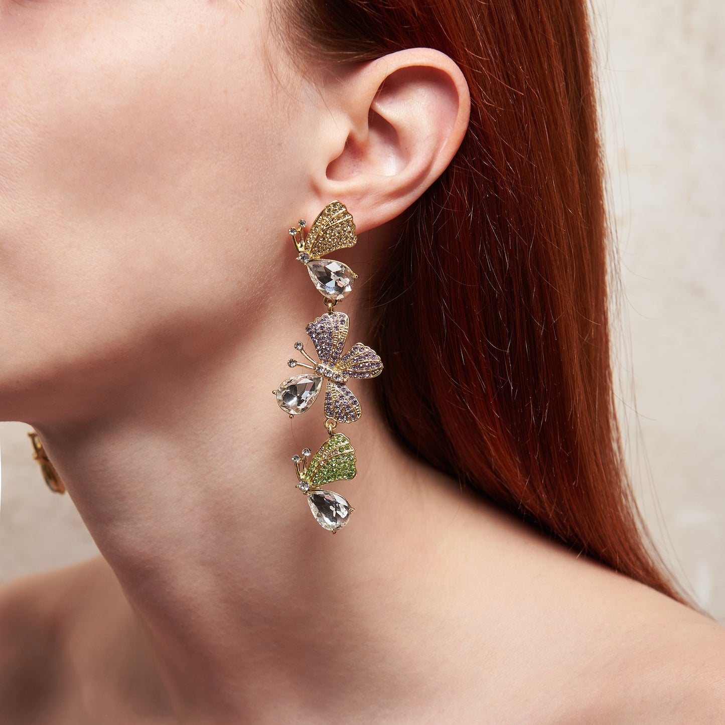 Statement maxi drop earrings with three golden butterflies adorned with sparkling details. Bold and elegant design.