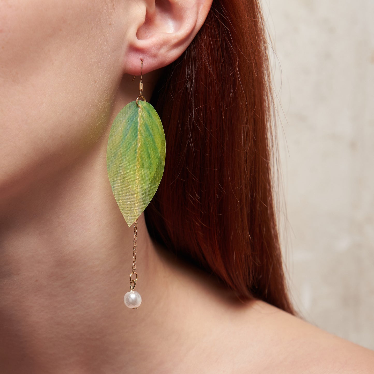 Extra-long dangle earrings inspired by lily of the valley. Lightweight fabric leaves and artificial pearl for a natural, refined look. 10 cm long. Zinc alloy for durability.
