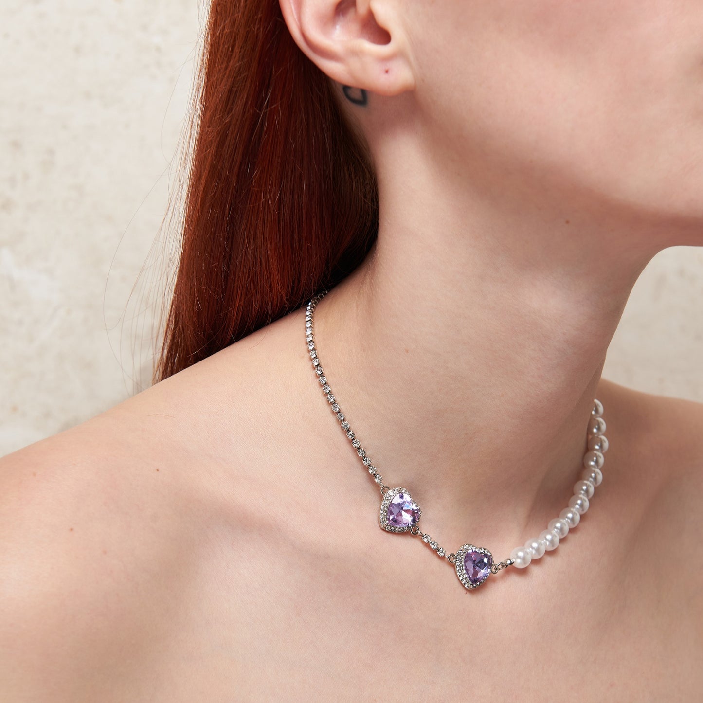 Bold fusion of baroque & punk style with zircon & artificial pearls. Adjustable, customisable. 2 lilac heart pendants for a punk rock touch, half romantic pearls, half glamorous silver chain. Statement necklace for baroque punk style, combining opulence & rebellion.