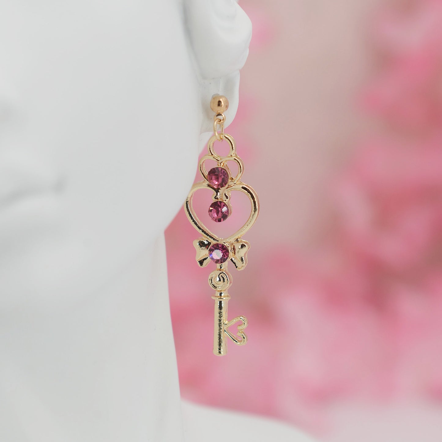 Asymmetrical earrings, inspired by the warriors' scepter from Sailor Moon. One earring features a sleek, scepter design with delicate details, the other showcases a crescent moon charm for a celestial touch.