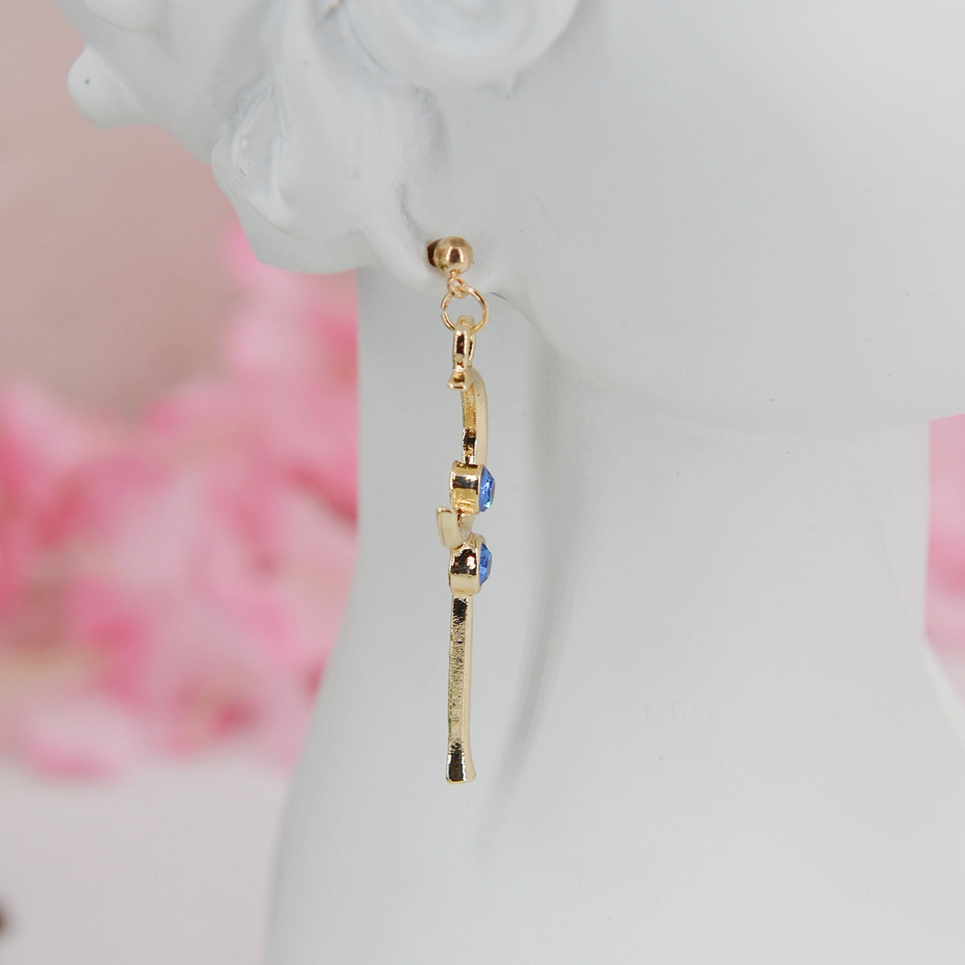 Asymmetrical earrings, inspired by the warriors' scepter from Sailor Moon. One earring features a sleek, scepter design with delicate details, the other showcases a crescent moon charm for a celestial touch.